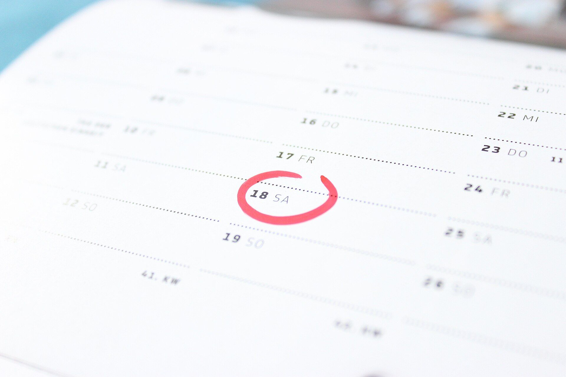 Planner page with Saturday the 18th circled in red and a printed calendar-week number below the dates