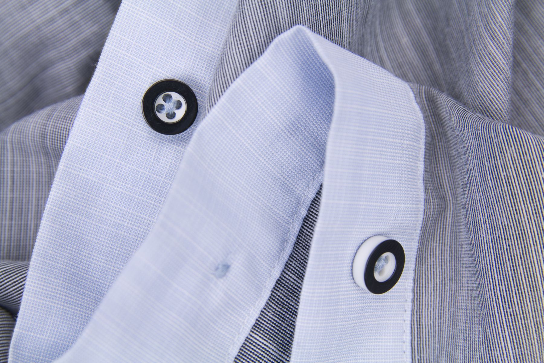 Buttoned collar and placket detail on a checked shirt