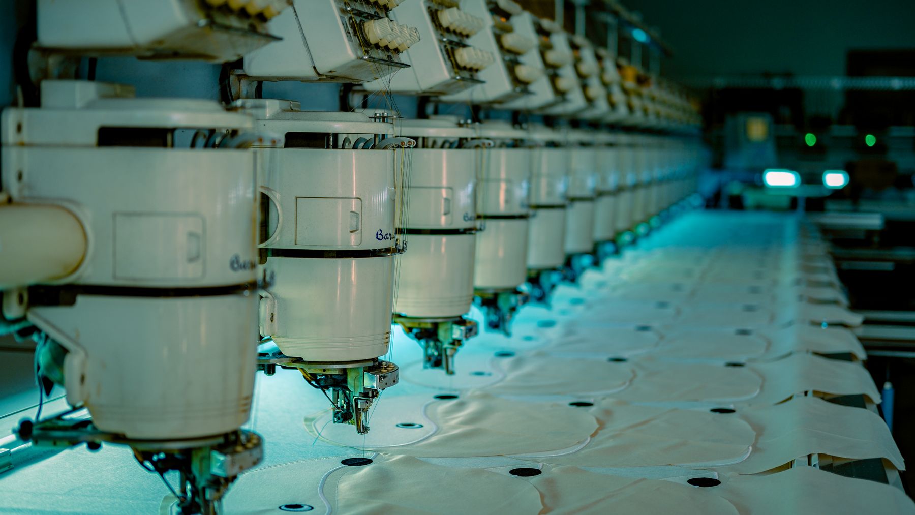 Row of industrial embroidery machines running on a garment factory production line