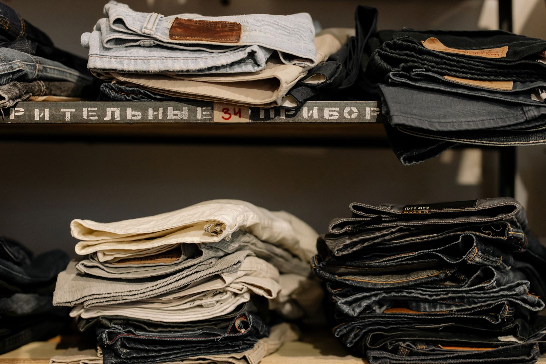 Folded garments stacked in even piles on retail shelving