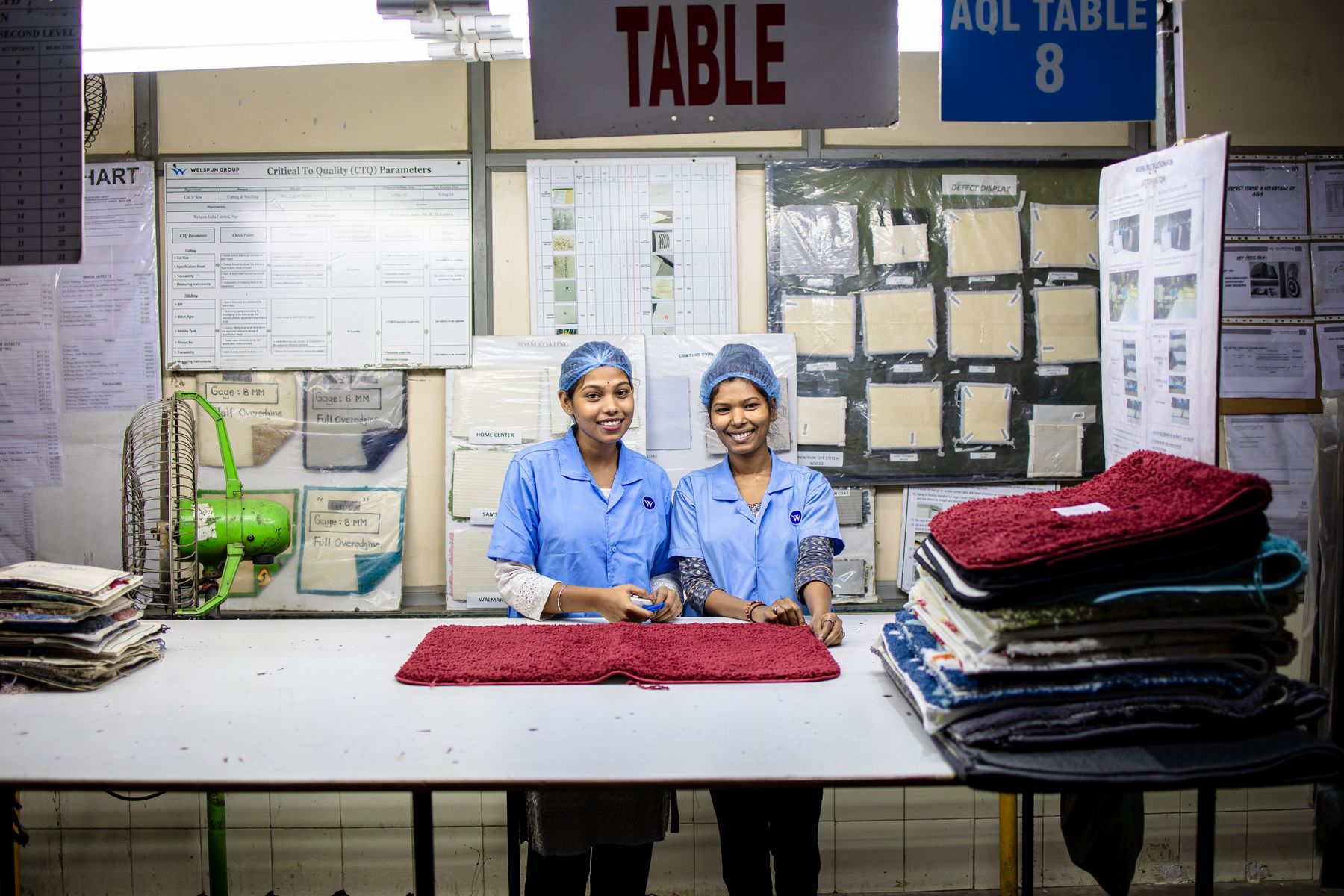 Two workers checking goods at a factory inspection table