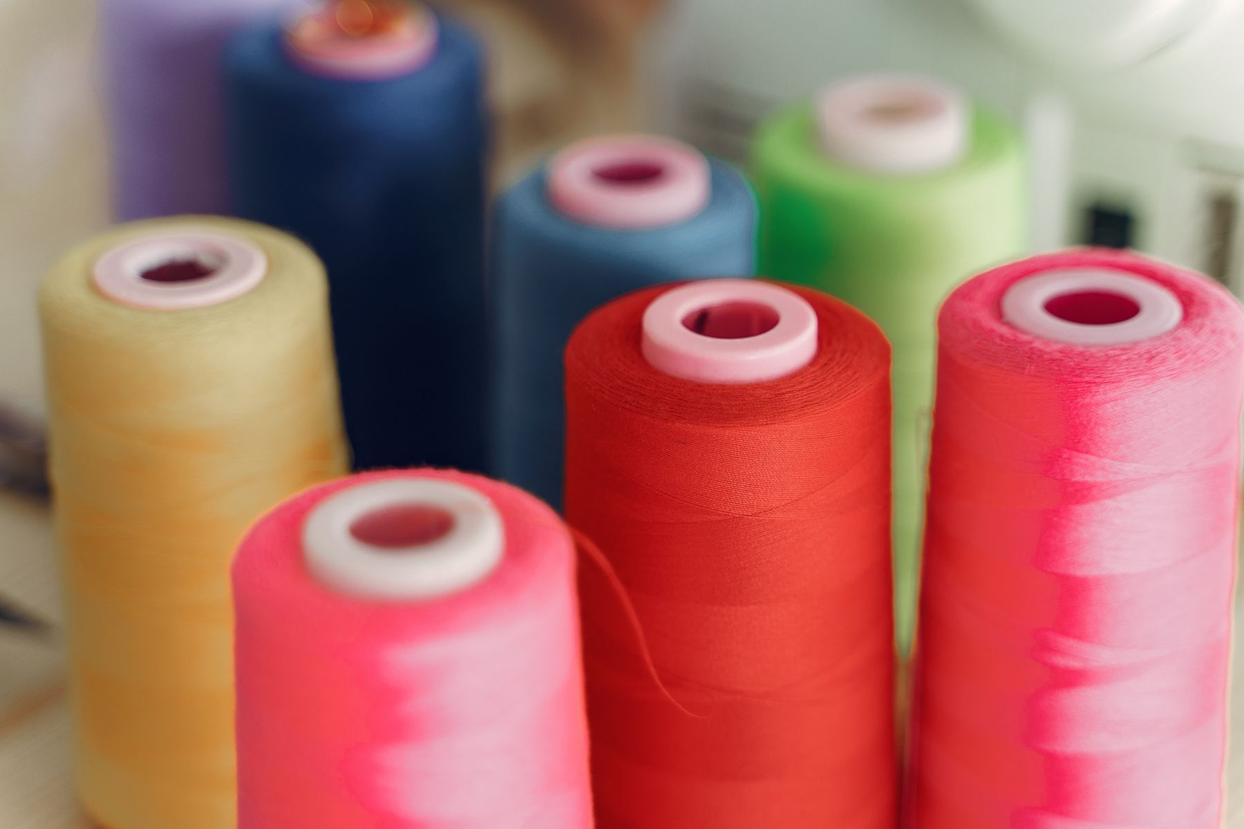 Cones of coloured thread beside a machine