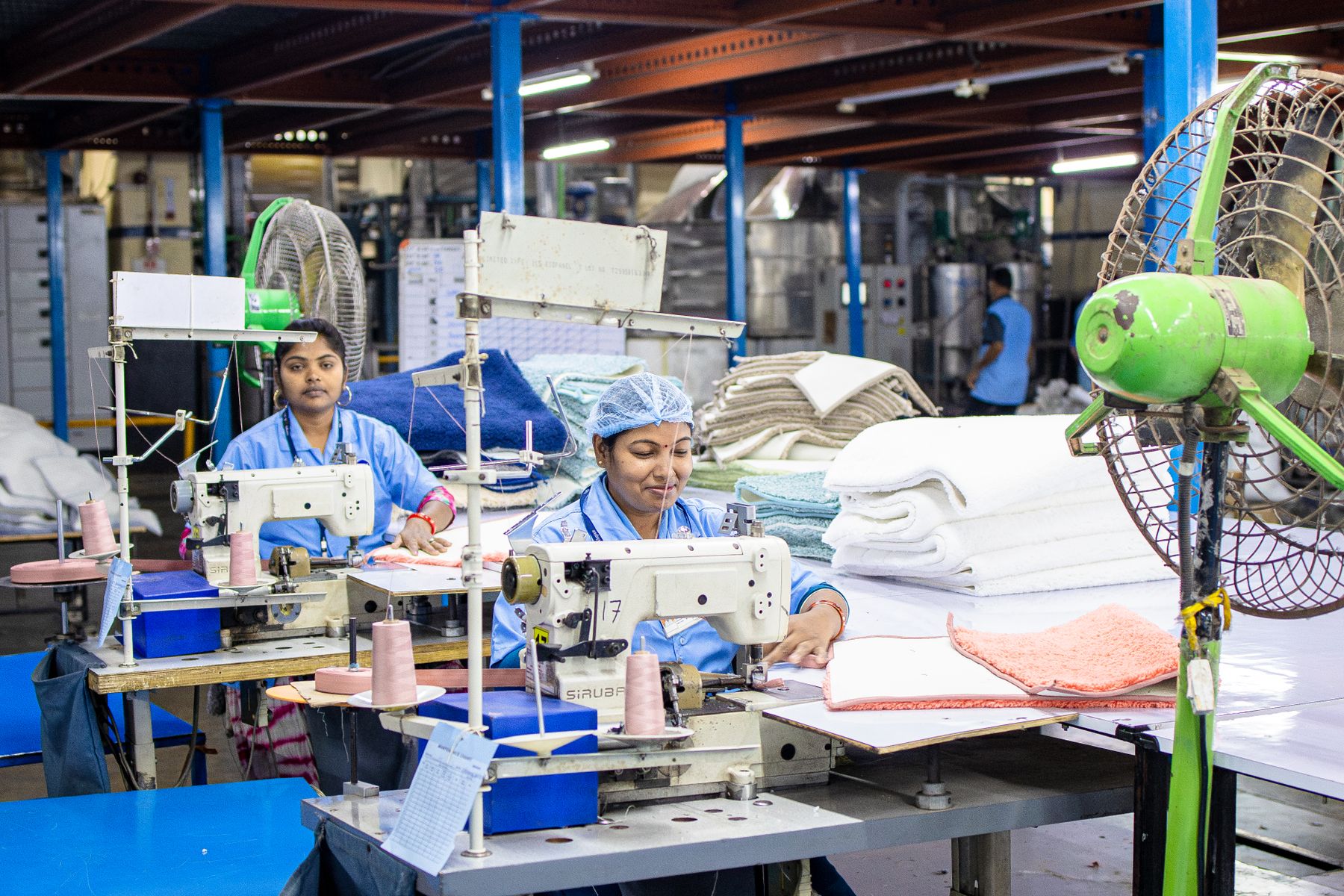 Sewing workstation with stacked finished pieces in a production hall