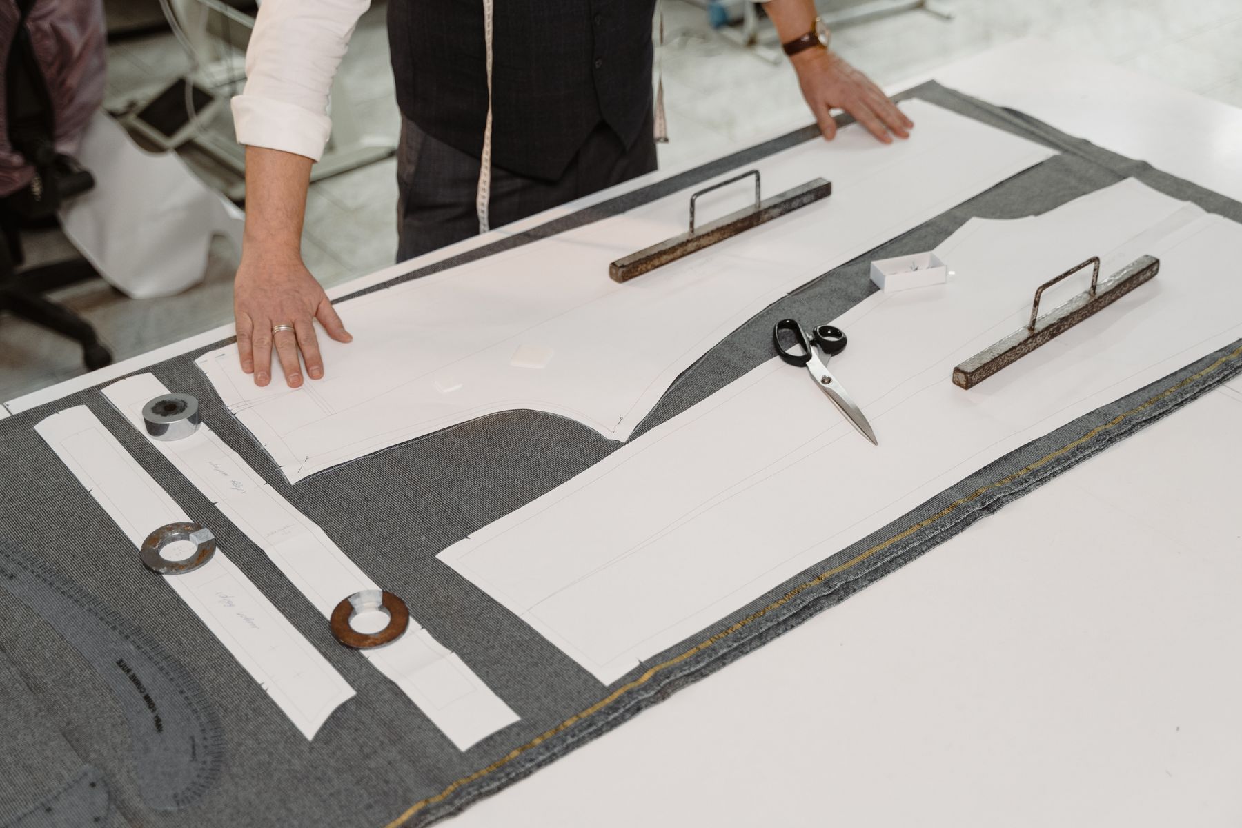 Pattern pieces laid out across spread fabric on a cutting table