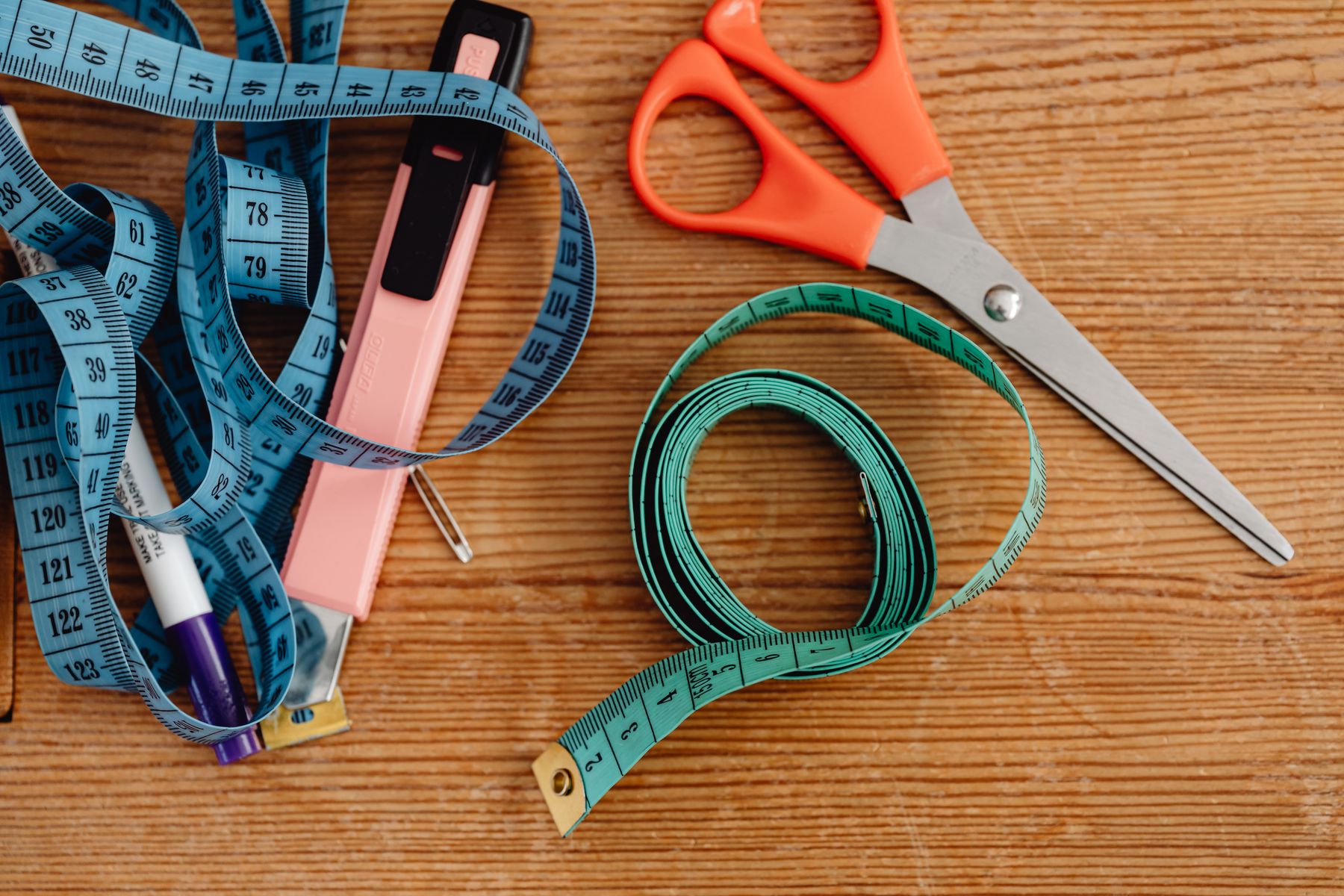 Tape measures, scissors and marking tools laid out on a workbench