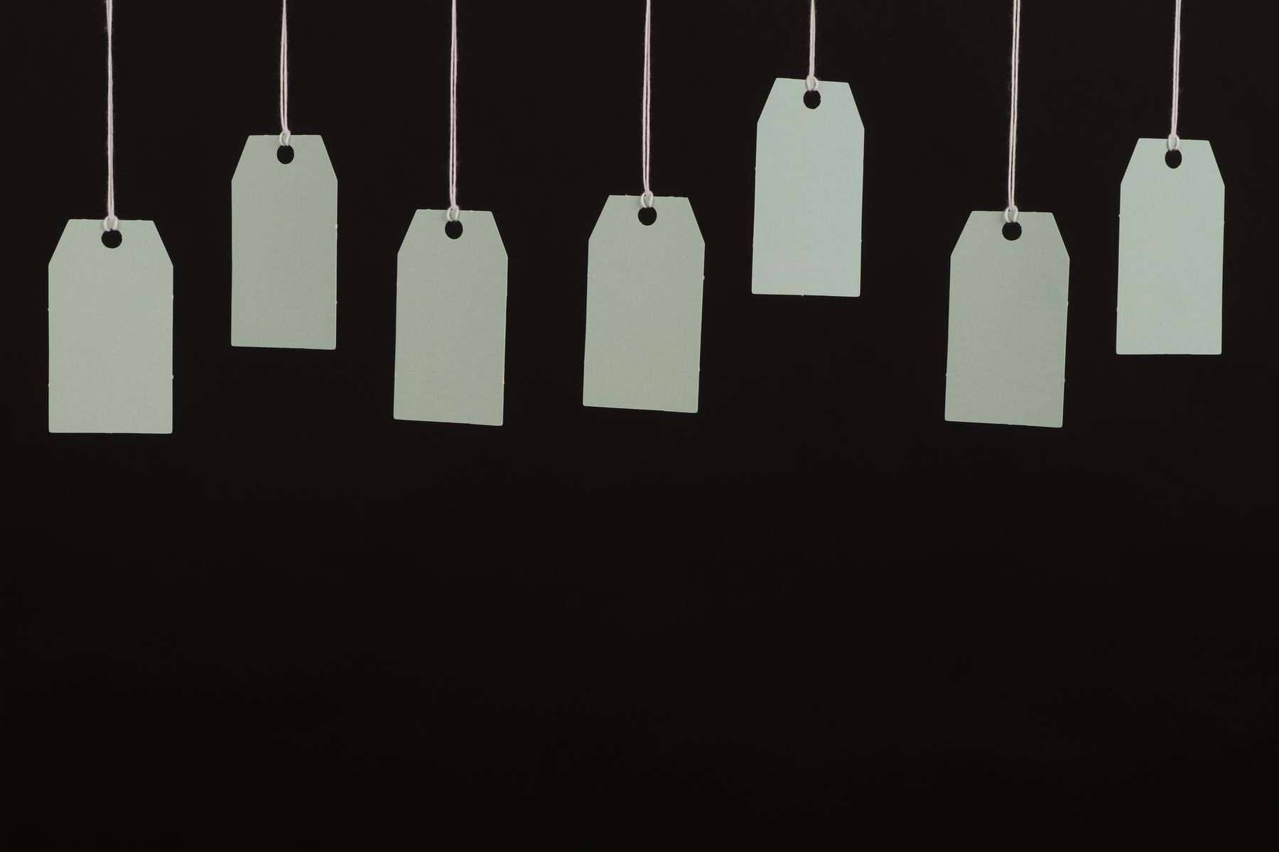 Row of blank hang tags suspended on strings