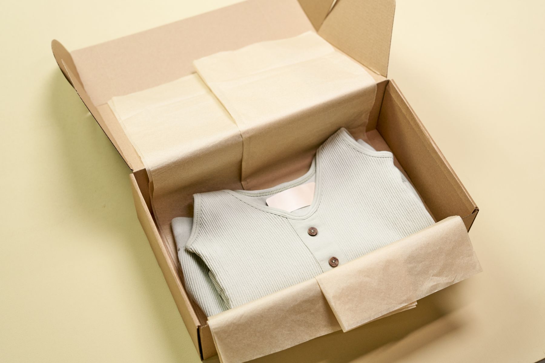 Folded garment packed in a box between sheets of tissue