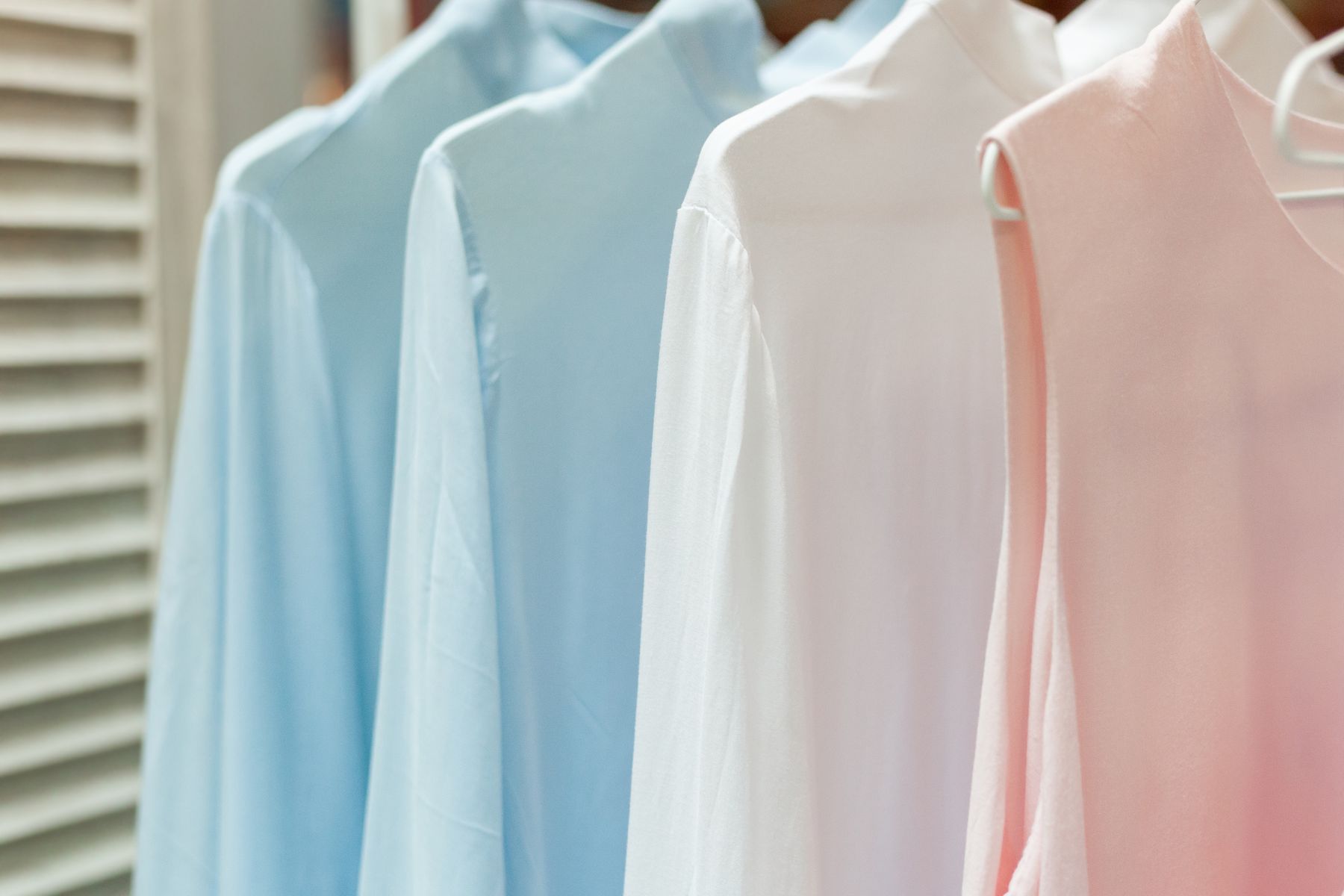 Row of pale blue, white and pink sleepwear pieces hanging on a rail
