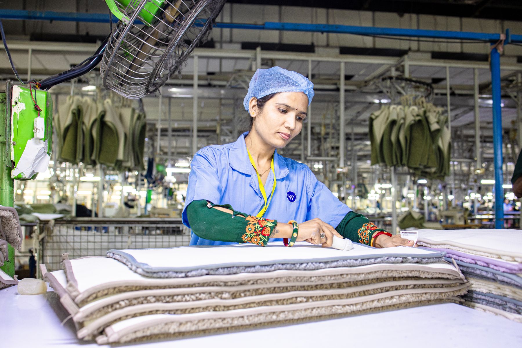 Worker checking and folding finished garments in a factory