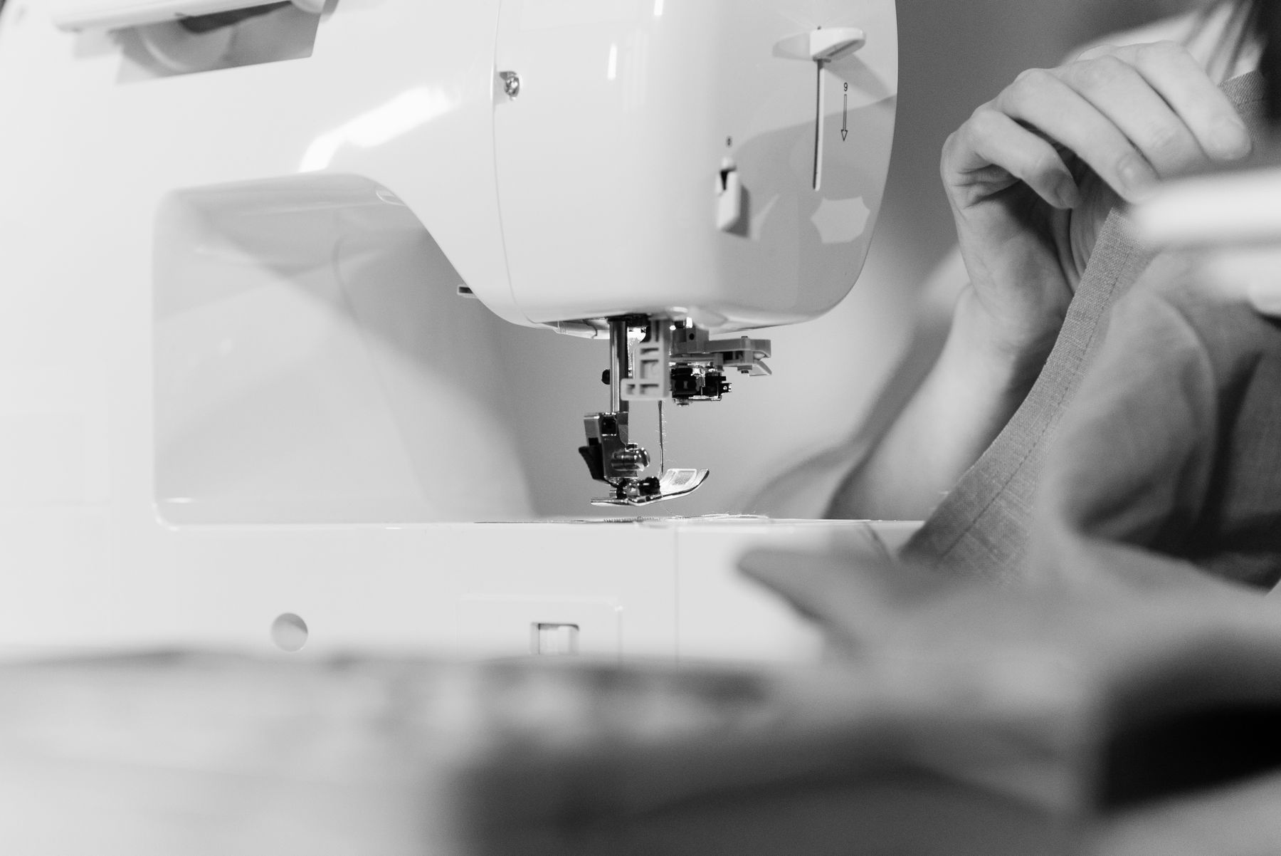 Hands guiding fabric through a sewing machine