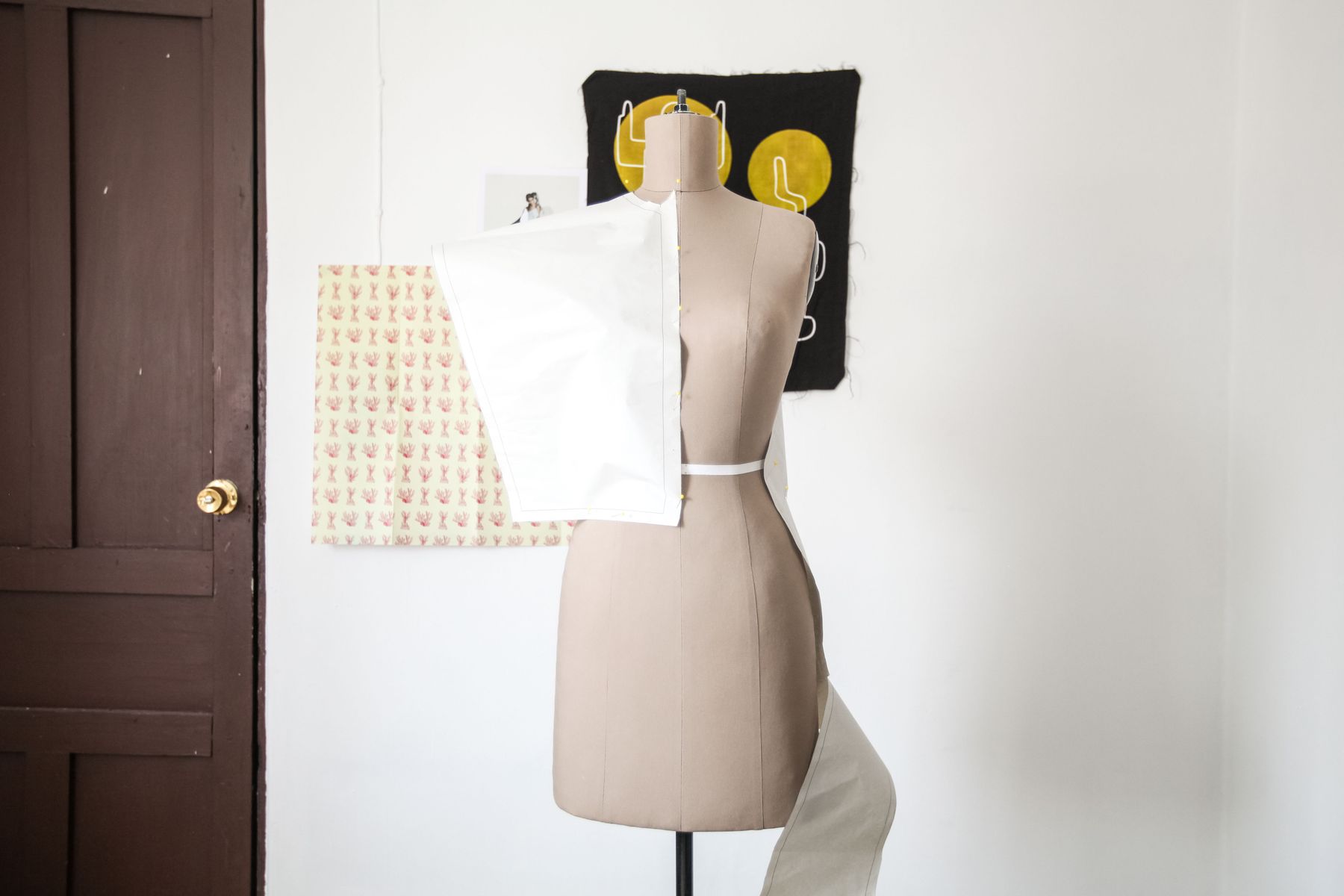 Dress form with pattern paper pinned to it in a sample room