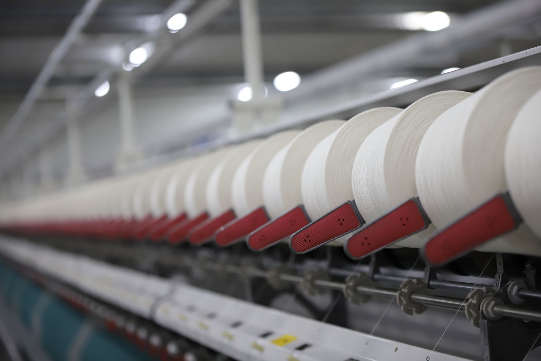 Row of yarn cones feeding an industrial knitting machine