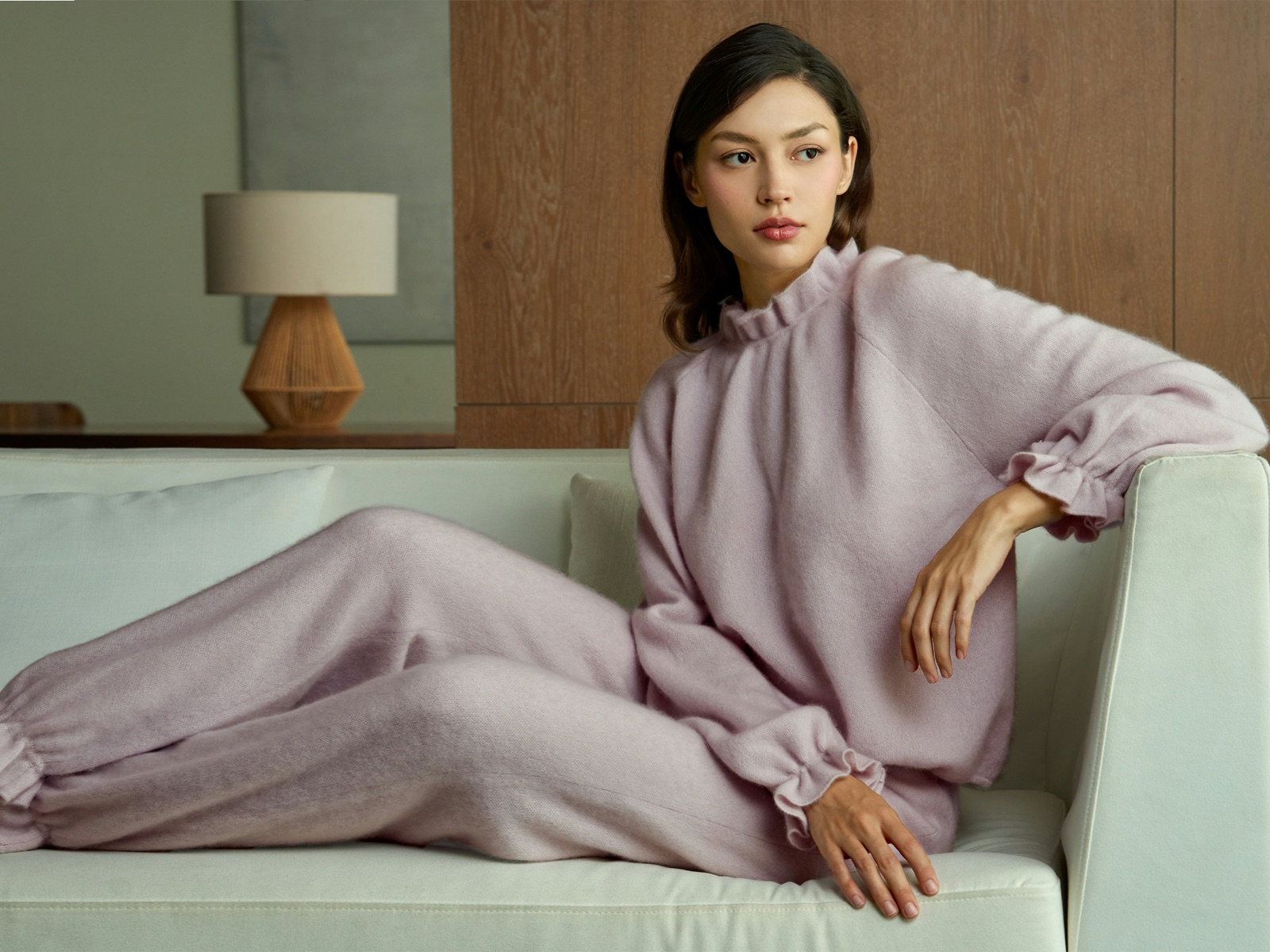 Woman wearing a lavender knit lounge set on a sofa