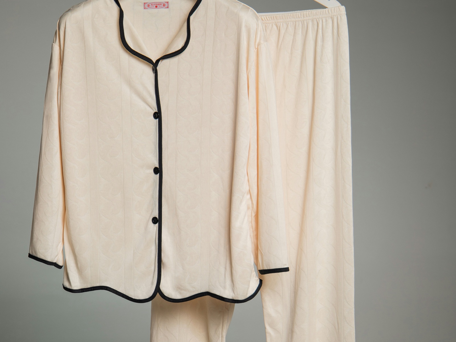 Cream button-front pajama set with contrast piping on hangers