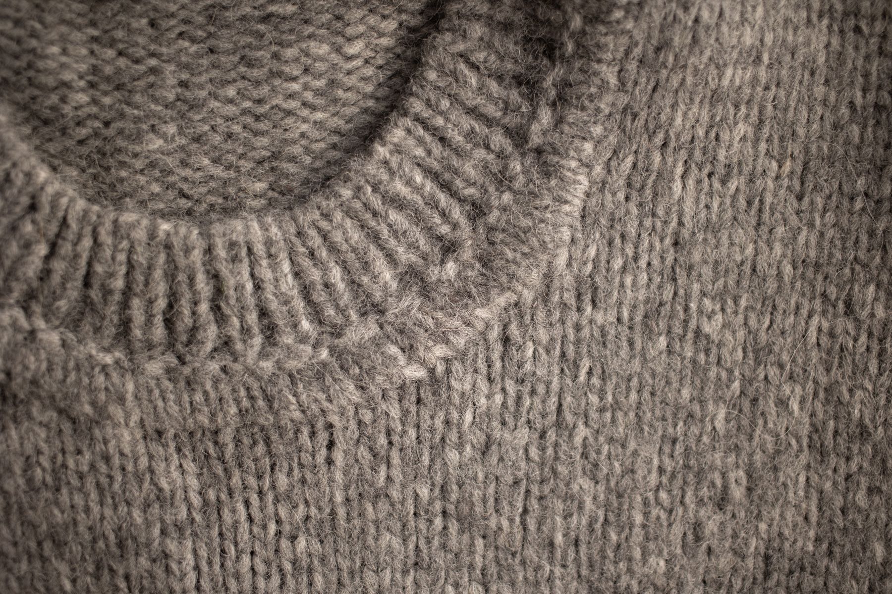 Close-up of the ribbed neckline on a grey knitted sweater