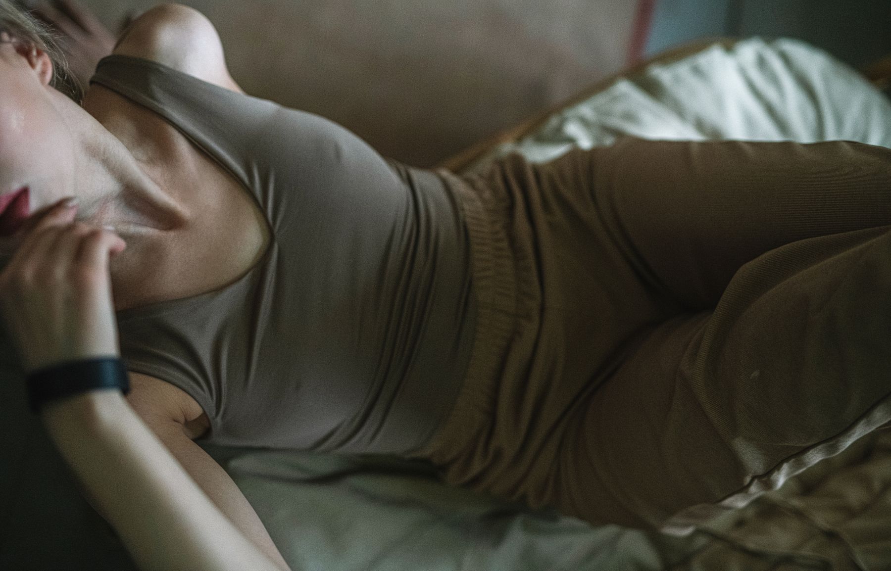 Woman in a lounge set resting on a bed