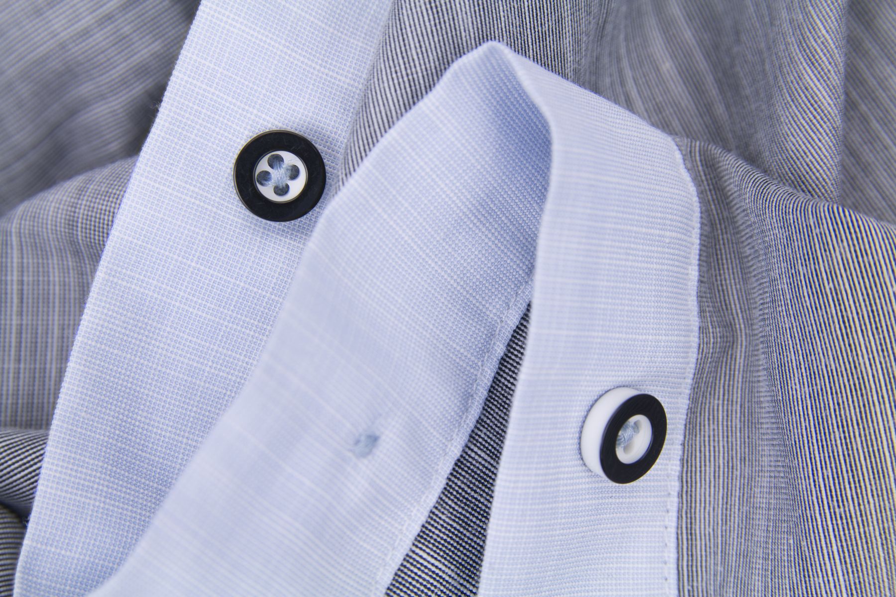 Buttoned collar and placket detail on a checked shirt