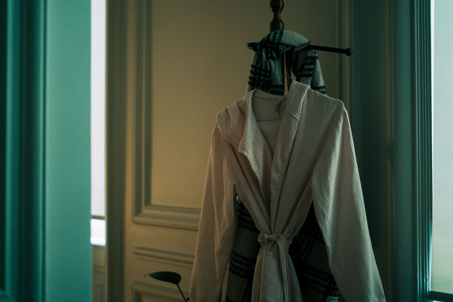 Robe hanging on a hook in a green painted room