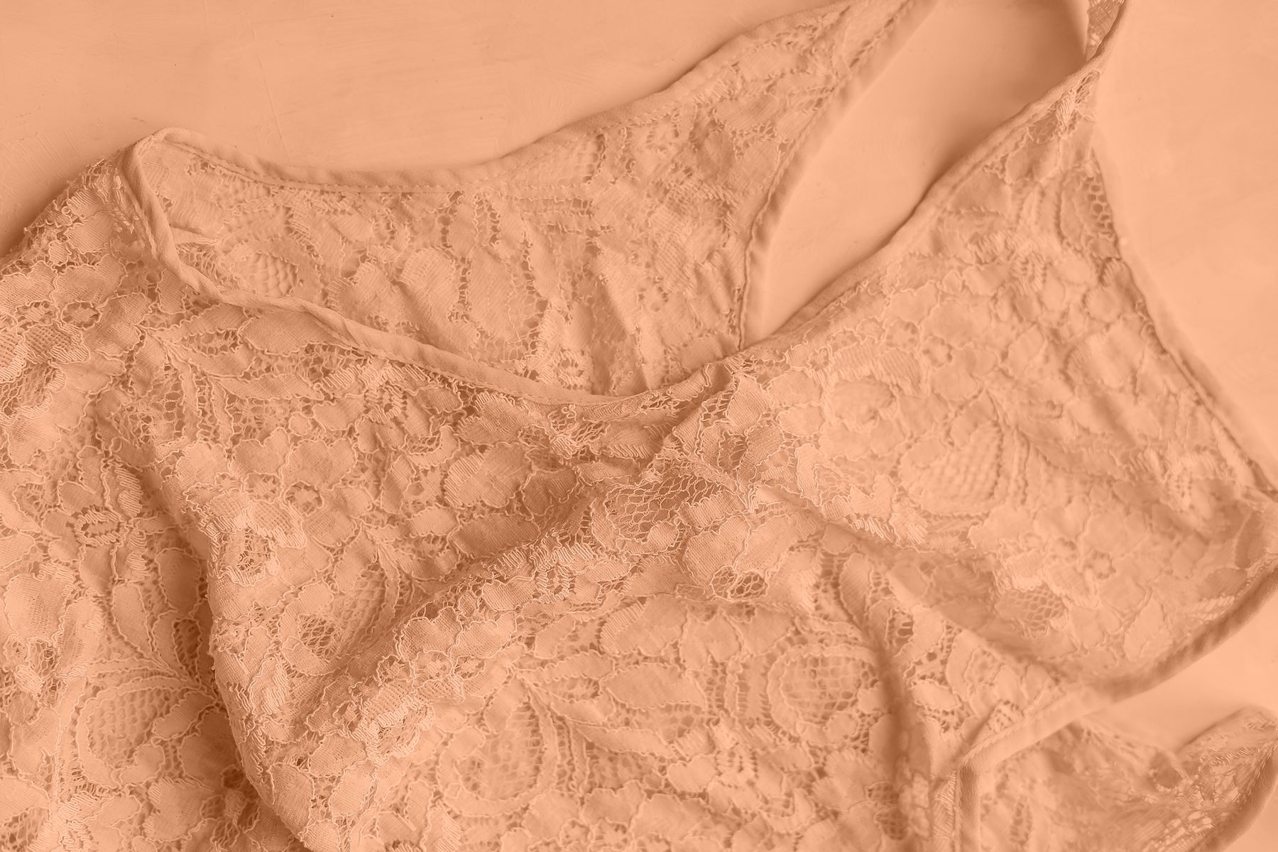 Close-up of peach lace trim on lightweight fabric